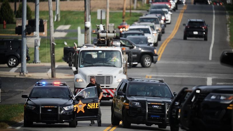 Clark County sheriff's deputies block the road and an Ohio Edison truck is shown as traffic backs up in Moorefield Township on Monday. A man climbed a power substation, and electricity was our for nearly 2,500 customers in the Northridge area before the man could be talked into coming down. MARSHALL GORBY/STAFF