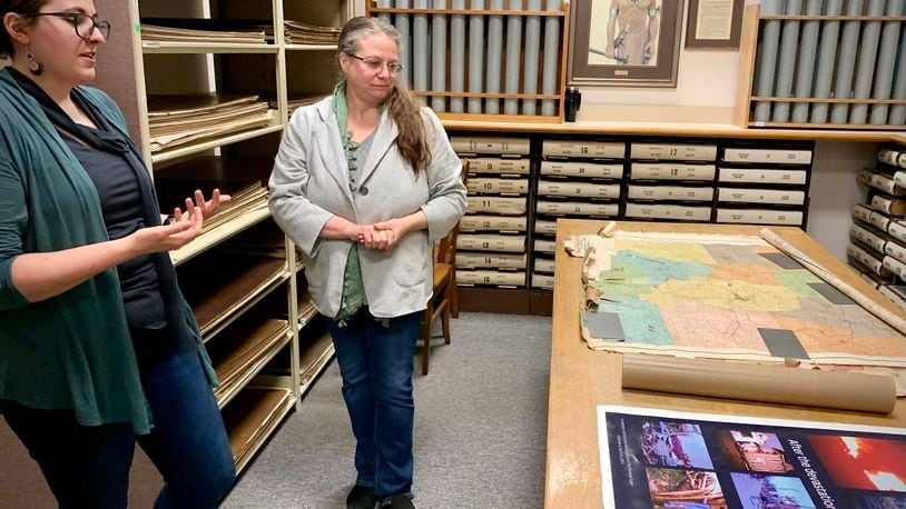Greene County Archivists Mary McKinley (left) and Robin Heise (center) explain the various exhibits the department has developed for the 50th anniversary of the 1974 tornado. LONDON BISHOP/STAFF