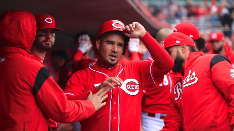 The Reds Eugenio Suarez returns to the dugout after scoring against the Cubs on Monday, April 2, 2018, at Great American Ball Park in Cincinnati. David Jablonski/Staff