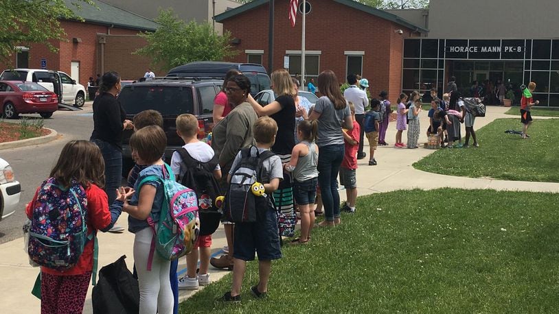 Students, teachers and parents gather outside Horace Mann Elementary School in Dayton at the end of a school day. Horace Mann had the second-highest attendance rate of Dayton Public Schools in the first semester. JEREMY P. KELLEY / STAFF