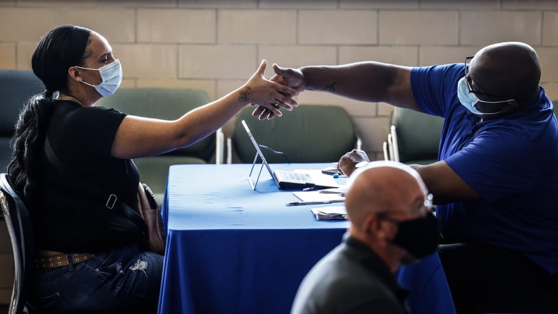 In this file photo, Mary Johnson shakes the hand of Dayton Public Schools human resources partner Andrae Hicks on Wednesday Sept. 29, 2021, after a job interview. JIM NOELKER/STAFF