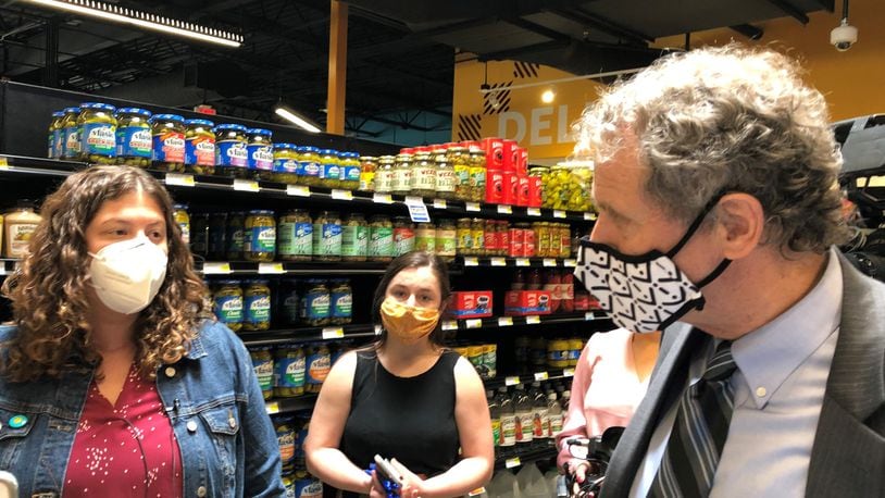 Sen. Sherrod Brown (D-Ohio) speaks with Lela Klein during a tour of the Gem City Market on Friday. Klein is on the market's board. CORNELIUS FROLIK / STAFF