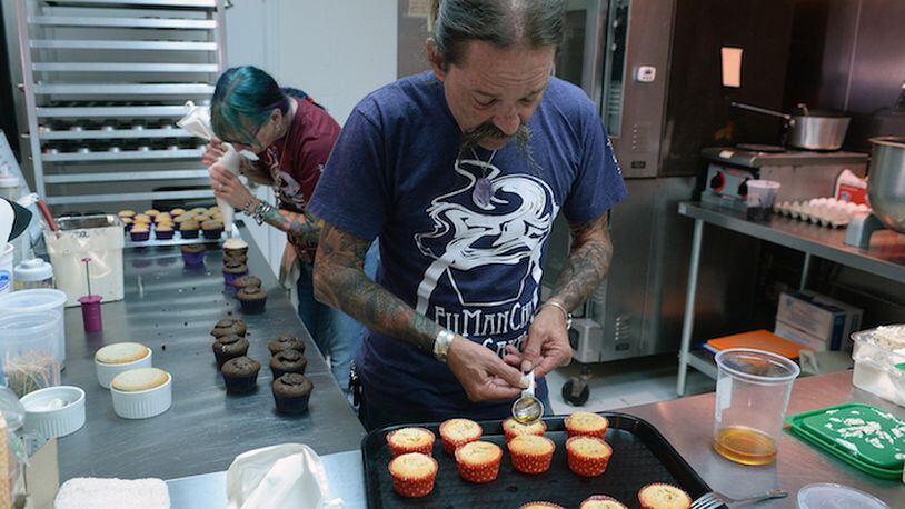 With his wife Beth taking care of his other cupcake creations, Andy carefully pours cinnamon whiskey into his his freshly baked "Flaming Peach" cupcakes. (T. Ortega Gaines/Charlotte Observer/TNS)
