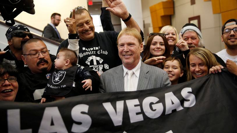 FILE - In this April 28, 2016, file photo, Oakland Raiders owner Mark Davis, center, meets with Raiders fans after speaking at a meeting of the Southern Nevada Tourism Infrastructure Committee in Las Vegas. (AP Photo/John Locher, File)