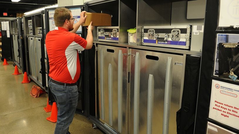 Cory Zimmerman, election services specialist at the Montgomery County Board of Elections, looks over machines as employees prepared for today's election. MARSHALL GORBY\STAFF