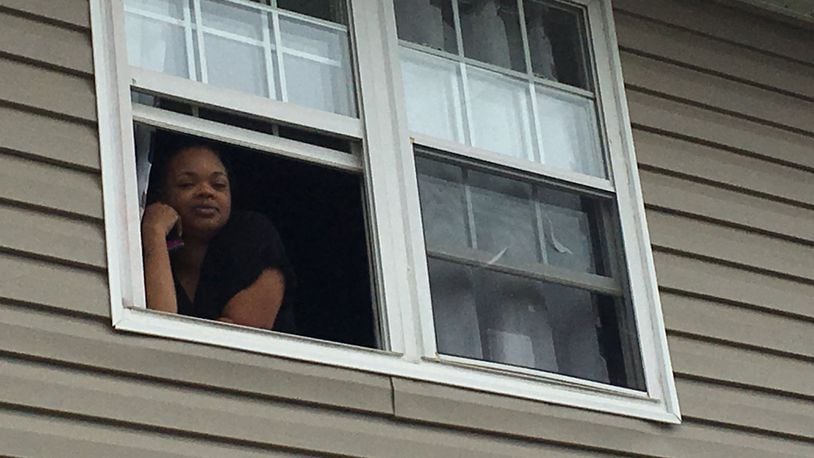 Destynee Gregory talks to a reporter from her second floor window at Meadowlark Apartments in Trotwood. She has two preschool age children, including one with a weakened immune system.