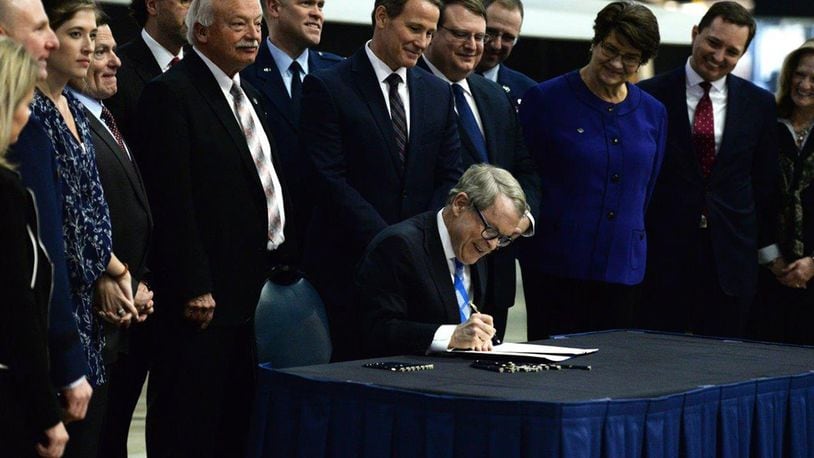 Ohio Gov. Mike DeWine signs Senate Bill 7 into law at the National Museum of the United States Air Force Jan. 27. The bill mandates Ohio agencies to issue licenses or certificates to qualifying military members and their spouses. (U.S. Air Force photo/Wesley Farnsworth)