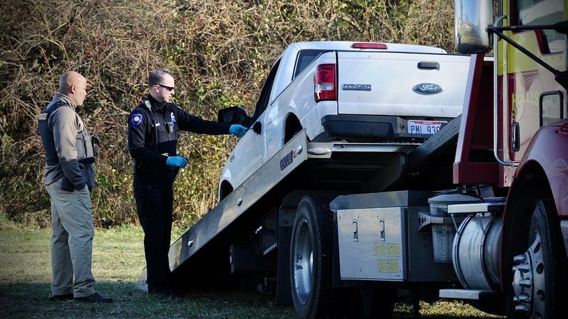 Huber Heights police dust for fingerprints on the driver's side of a white Ford Ranger stolen Tuesday, Nov. 30, 2021, from an Old Troy Pike auto shop after the suspect was involved in a kidnapping and fleeing from police. MARSHALL GORBY \STAFF