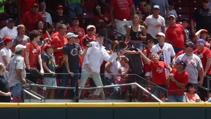A fan catches a home run hit by the Rockies against the Reds on Wednesday, June 21, 2023, at Great American Ball Park in Cincinnati. David Jablonski/Staff