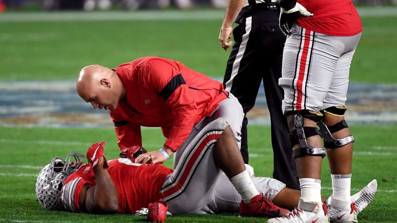 GLENDALE, ARIZONA - DECEMBER 28: J.K. Dobbins #2 of the Ohio State Buckeyes is checked by the trainer against the Clemson Tigers in the first half during the College Football Playoff Semifinal at the PlayStation Fiesta Bowl at State Farm Stadium on December 28, 2019 in Glendale, Arizona. (Photo by Norm Hall/Getty Images)