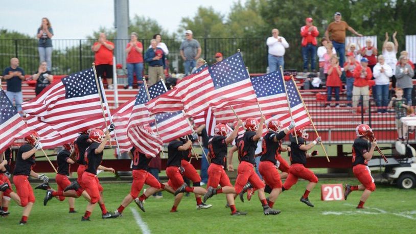Milton-Union High School football players take the field waving American flags to honor the U.S. response to 9/11. Milton-Union defeated visiting Northridge 69-35 in the Week 4 SWBL game on Friday, Sept. 15, 2017. CONTRIBUTED PHOTO