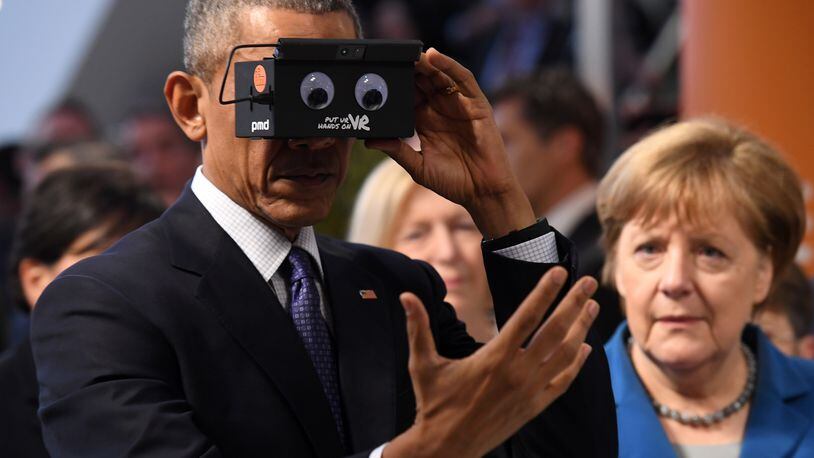 HANOVER, GERMANY - APRIL 25: U.S. President Barack Obama and German Chancellor Angela Merkel test virtual reality glasses at the ifm electronics stand at the Hannover Messe industrial trade fair on April 25, 2016 in Hanover, Germany. This is likely Obama's last trip to Germany as U.S. president. The Hannover Messe is the world's largest industrial trade fair. (Photo by Alexander Koerner/Getty Images)