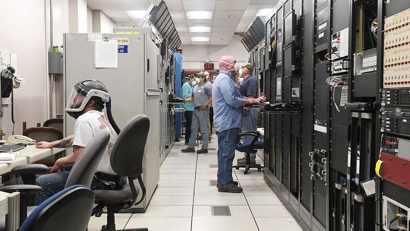 Seven Hroncich (left), an instrument technician, Robert Bradford (center right), an electrician, Kevin Thompson (right), test operations engineer, Tim Mullins, an outside machinist, and others prepare for a test run in the Arnold Engineering Development Complex Arcs Test Facility Control Room, May 5 at Arnold Air Force Base, Tenn. (U.S. Air Force photo/Jill Pickett) (This image was altered by obscuring items for security purposes.)
