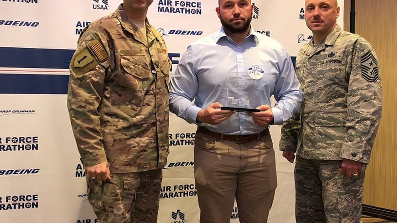 Col. Thomas Sherman (left), 88th Air Base Wing and installation commander, and Chief Master Sgt. Stephen Arbona, 88 ABW command chief, present the Air Force Marathon Expo Volunteer of the Year award to Eric Hoehne at a volunteer reception held Oct. 17 at Soin Medical Center. (Courtesy photo)