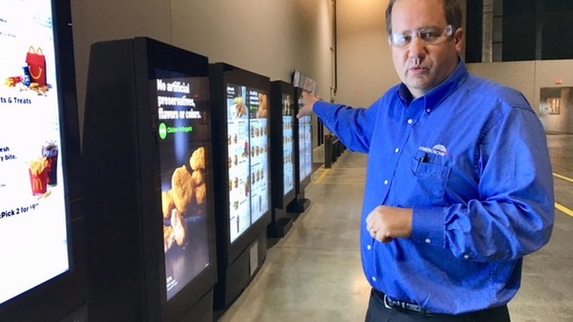 Chris Riegel, founder and chief executive of Stratacache, runs a company based in Dayton but increasingly busy in a part of the globe that has two-thirds of the world’s population. Here, he shows an array of the company’s digital menu displays. THOMAS GNAU/STAFF