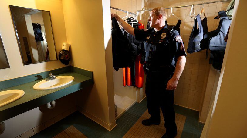 Sgt. Michael Hummel hangs a ballistic vest in a shower stall in the men’s locker room at the Beavercreek Police Dept. The locker room no longer has adequate space for the officers and the lockers are to small for the vests to fit inside. LISA POWELL / STAFF