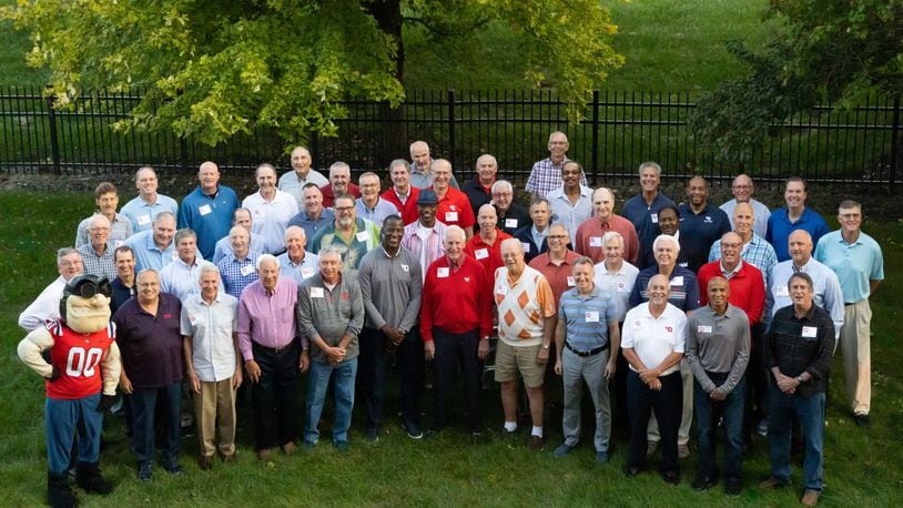 Former Dayton coach Don Donoher, center in red, poses for a photo with his former players at a reunion on Oct. 9, 2021, in Dayton.Pictured are: ROW 1: Rudy Flyer; Bobby Hooper; Joe Emmrich; Jim Larkin; Rex Gardecki; Anthony Grant; Don Donoher; Chris Harris; John Cortney; Gary McCans; Russ Willis; and Paul Donoher.ROW 2: Jim Stiff; Dave Pressley; Dan Christie; Robert Urbanowicz; Dave Borchers; Tom Crosswhite; Roosevelt Chapman; Kevin Conrad; Greg Ellison; Al Bertke; Mike Byrd; and Damon Goodwin.
ROW 3: Dan Sadlier; George Janky; Mark Knue; Brian Donoher; Steve Hess; Pat Murnen; George Morrison; Gene Klaus; Doug Harris; Ken May; J.D. Grigsby; Mike Sylvester; and Ed Young.
ROW 4: Mike Kanieski; Bill Uhl; Tim Pohlman; Don May; John Samanich;  Dan Herling; Steve Turnwald; Fred Eckert; Leighton Moulton; Jack Zimmerman; Nolan Robinson; and Bill Crotty. Photo courtesy of Natalie Schindler Photography
