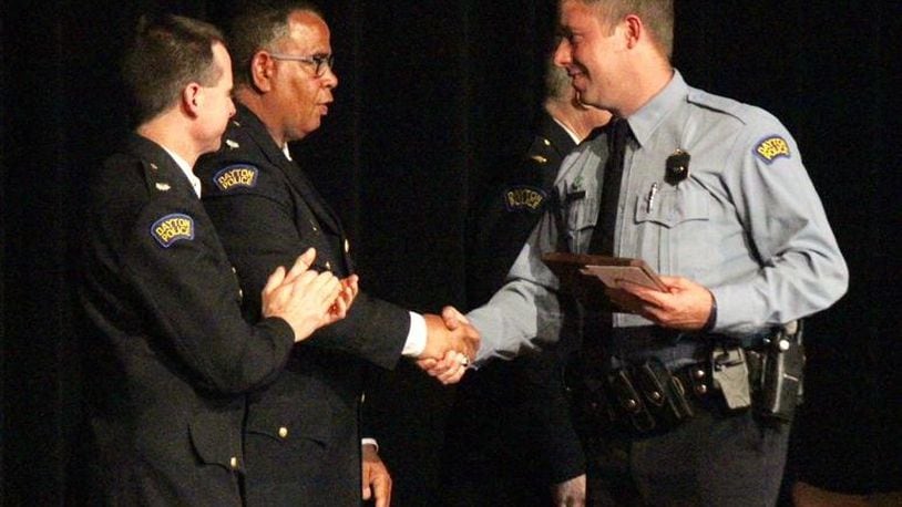 Dayton police officer Jason Olson, right, recipient of the Steve Whalen Memorial Policing Award, shakes hands with Lt. Col. Mark Ecton. CHUCK HAMLIN / STAFF