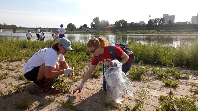 Employees of Cox Media Group Ohio cleaned up debris along the Great Miami River in Dayton Friday during Clean Sweep 2014. The Clean Sweep effort is organized by groups including American Rivers and Five Rivers MetroParks. LISA POWELL / STAFF