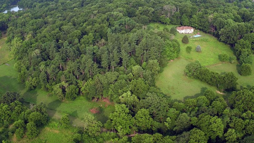 The Kircher family is looking to create Bellbrook Mountain snowtubing, skiing, snowboarding and sledding on family land that includes a steep wooded hillside already carved with trails. This aerial view looking west shows the hillside. TY GREENLEES / STAFF
