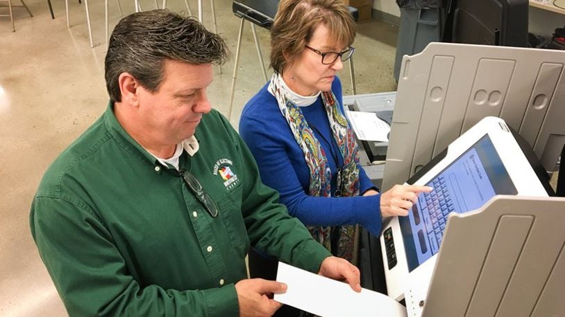 Montgomery County Board of Elections Director Jan Kelly and Deputy Director Steve Harsman give a presentation to county commissioners on the touch-screen hybrid voting system the elections board members recommended. CHRIS STEWART / STAFF