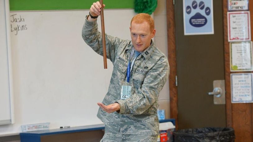 Capt. Brigham Moore, Air Force Institute of Technology/CEM, a volunteer with the Educational Outreach Program at Wright-Patterson Air Force Base, presents first graders at Clearcreek Elementary School, Springboro, Ohio, a demonstration on magnets. The Magnets Demo is one of the many programs offered by the Educational Outreach Program to attract student’s interest in careers in science, technology, engineering and math. (U.S. Air Force photo/Kwame Acheampong)