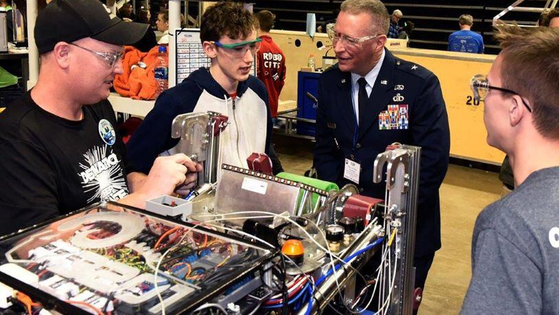 Brig. Gen. Brian Bruckbauer, Air Force Security Assistance and Cooperation Directorate director, listens to Ross High School team members as they prepare to compete in the in the Miami Valley FIRST Robotics Regional Competition at the Wright State University Nutter Center Feb. 28. (U.S. Air Force photo/Ty Greenlees)