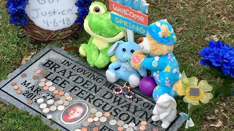 Toys and a handmade wreath declaring "I Got Justice 4-6-18" adorn Brayden Ferguson's grave site at Dayton Memorial Park.