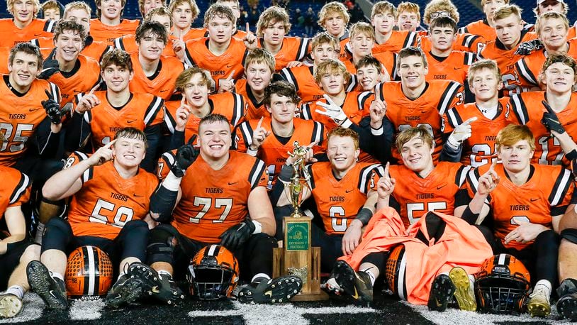 Cutline: The Versailles High School football team poses with the trophy after beating Kirtland 20-16 to win the Division V state championship game on Saturday night at Tom Benson Hall of Fame Stadium in Canton. Michael Cooper/CONTRIBUTED