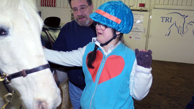 Dave Ball helps his student Kara get to know a horse. Ball devotes about 200 hours per year to volunteering for TRI and helping disabled kids through horse therapy. CONTRIBUTED