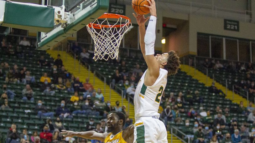 Wright State's Tanner Holden goes in for a dunk over Tafari Simms off a Milwaukee turnover early in Thursday night's game at the Nutter Center. Jeff Gilbert/CONTRIBUTED
