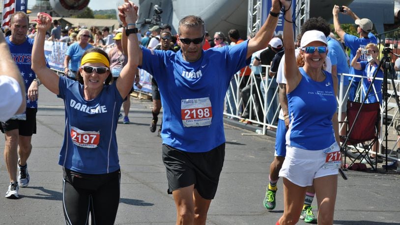 Major Ivan Castro (retired) finishes Saturday’s Air Force Marathon. To his side are Darlene Matos on his left and Jackie Ferguson on his right. Castro, who was blinded while serving in Iraq in 2006, is the only blind Special Forces officer in U.S. Army history. NICK DUDUKOVICH / CONTRIBUTED