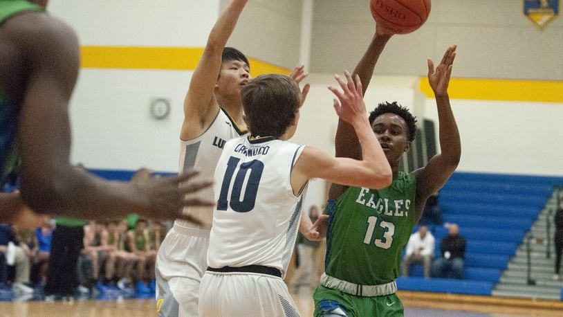 Chaminade Julienne’s Brandon Gibson passes over Oakwood’s Jack Epley (10) and Daniel Hu in the first half of Wednesday night’s Division II sectional semifinal at Springfield High School. Jeff Gilbert/CONTRIBUTED