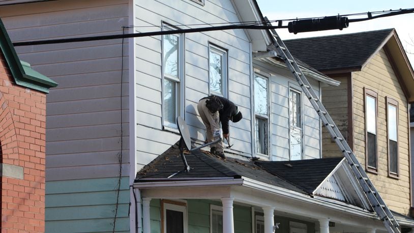 A man performs roof work on a home in Dayton. CORNELIUS FROLIK / STAFF