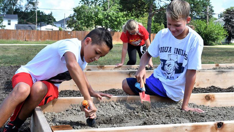 Fifth-graders at Piqua Central Intermediate School do initial work in the dirt of new garden boxes in preparation for planting as part of a new project being led by Miami County Master Gardener volunteers. CONTRIBUTED