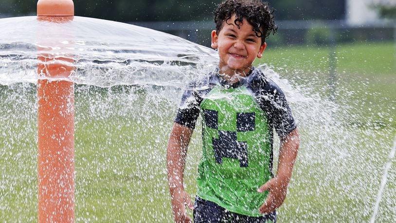 Ian Bailey, 4, cools off in the water at the spray ground at Booker T. Washington Community Center Monday, June 13, 2022 in Hamilton. NICK GRAHAM/STAFF