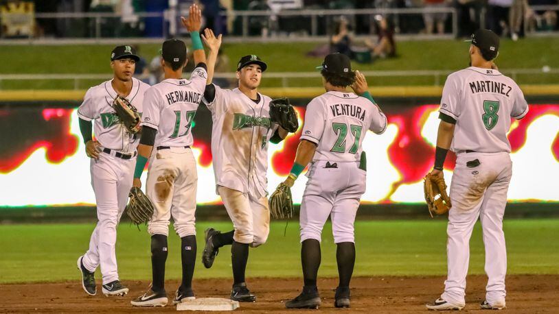 Dayton Dragons center fielder Michael Siani (center) celebrates with teammates after the team’s 5-4 victory over West Michigan Whitecaps on Tuesday night at Fifth Third Field. Siani went 4-for-4 with an RBI in the victory and is hitting .447 over his last 10 games this month. CONTRIBUTED PHOTO BY MICHAEL COOPER