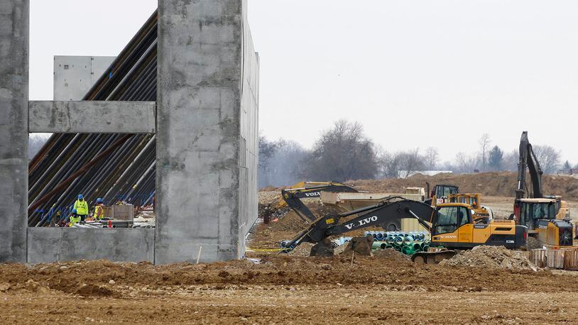 Long stabilizer bars run horizontally down from giant concrete wall sections at the new Crocs distribution center under construction at the Dayton Airport. TY GREENLEES / STAFF