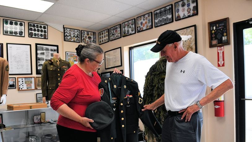Karen Purke discusses a uniform in the collection at the Miami Valley Veterans Museum with a visitor. Purke is the museum's executive director. CONTRIBUTED