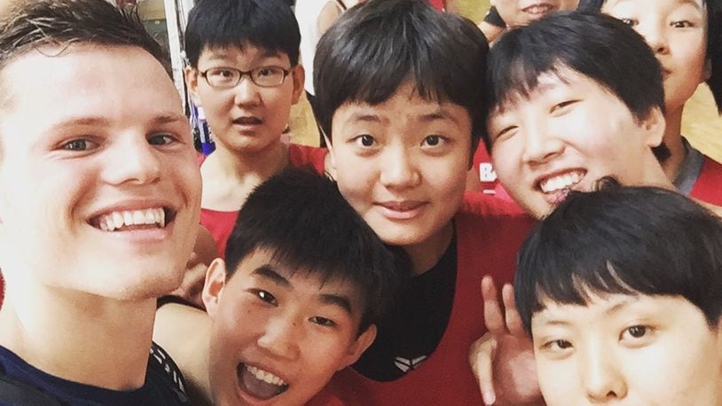 Wright State’s Grant Benzinger with young Chinese teens he befriended at basketball clinic. CONTRIBUTED PHOTO