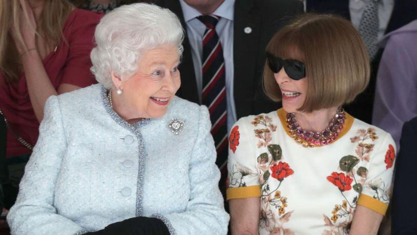 Queen Elizabeth II sits next to Anna Wintour as they view Richard Quinn's runway show before presenting him with the inaugural Queen Elizabeth II Award for British Design as she visits London Fashion Week's BFC Show Space on February 20, 2018 in London, United Kingdom.