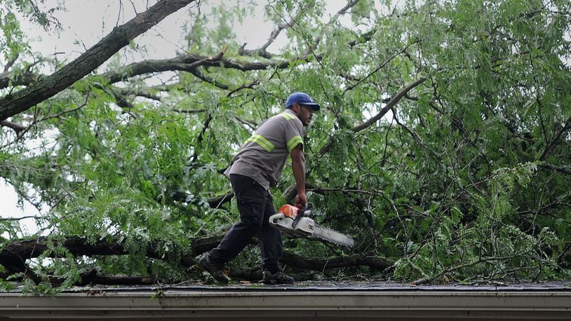 Cleanup was underway Monday, Aug. 22, 2022, after several trees fell onto apartments and a car at the Ketwood Apartments in Kettering Sunday when strong storms passed though at the area that prompted a tornado warning. MARSHALL GORBY\STAFF