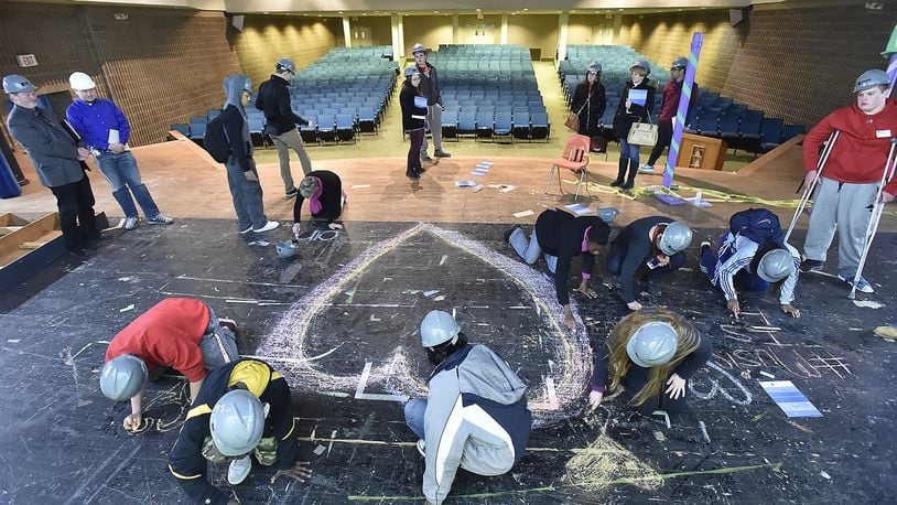 Springfield High School students use chalk to draw hearts on the stage in the auditorium at the former South High School. Springfield City School District alumni John Legend has announced plans to raise funds to renovate the auditorium. Bill Lackey/Staff