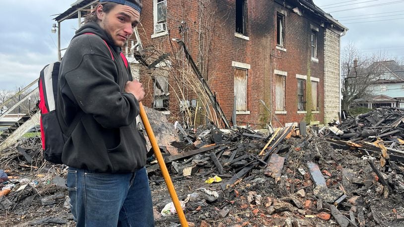 Jordan Trent, a 22-year-old homeless man, sifts through debris left over after a home on the 500 block of North Broadway Street burned down on March 8, 2023. Trent said he was in the home at the time of the fire and he thinks a couple of his friend might have been killed by the blaze. Dayton authorities recovered five bodies from the property after the fire. CORNELIUS FROLIK / STAFF