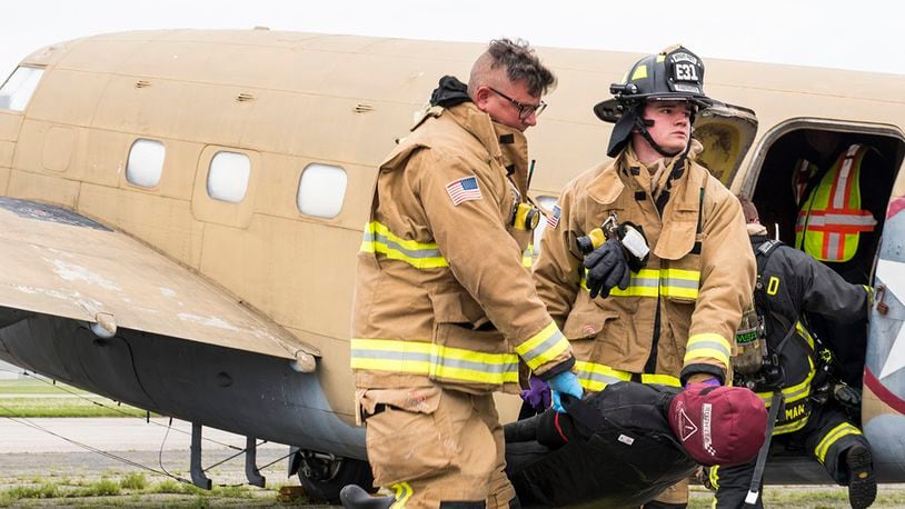 Firefighters from the 788th Civil Engineer Squadron carry a dummy victim to safety on May 5 during a mass casualty exercise at Wright-Patterson Air Force Base. The exercise involved a mock plane crash and gave first responders the opportunity to practice coordinating emergency action procedures. U.S. AIR FORCE PHOTO/JAIMA FOGG