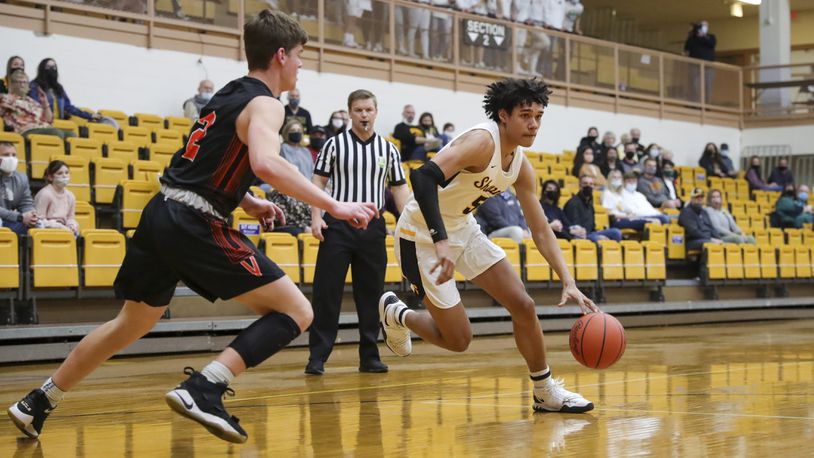 Shawnee High School sophomore Zion Crowe drives by Versailles senior Jared DeMange during their game on Wednesday night at the Vandalia Butler Student Activity Center. Crowe scored 18 points as the Braves advanced to a regional semifinal game for the first time since 1975. CONTRIBUTED PHOTO BY MICHAEL COOPER