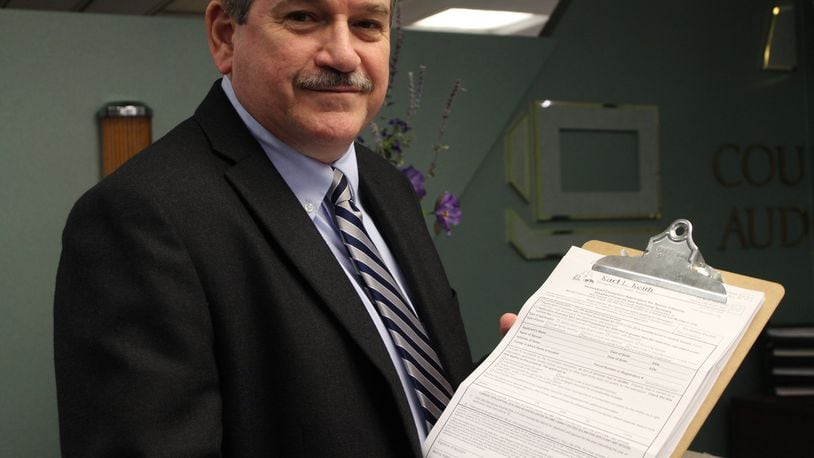Montgomery County Auditor Karl Keith holds up the forms residents must fill out to apply for the homestead exemption program. CORNELIUS FROLIK / STAFF