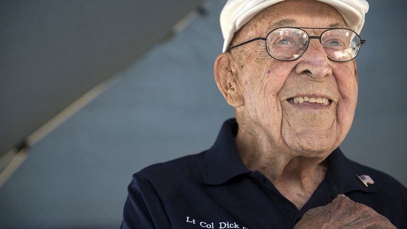 Retired Lt. Col. Richard E. Cole, copilot to Jimmy Doolittle during the Doolittle Raid, smiles as he honors the U.S. flag during the singing of the national anthem at an airshow in Burnet, Texas. Cole was honored by the community and guests as the only remaining military service member alive from the April 18, 1942, Doolittle Raid. (U.S. Air Force photo/Staff Sgt. Vernon Young Jr.)