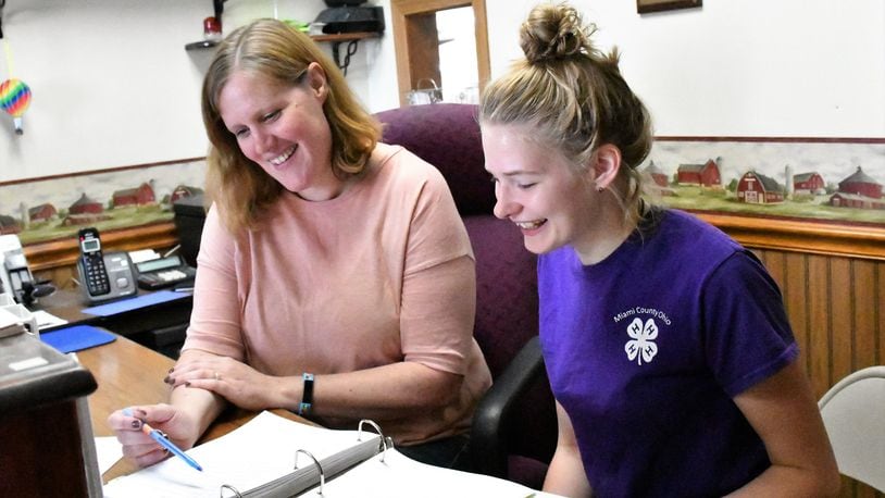 Jill Wright, secretary/manager of the Miami County Fair, at left, talks with Kelci Cooper, a 4-H member and Junior Fair Board member about preparations for the 2018 fair that runs Aug. 10-16 at the fairgrounds just north of Troy. CONTRIBUTED