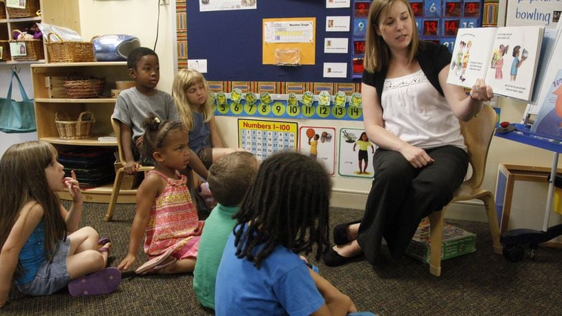 Stephanie Williams, a teacher at Miami Valley Hospital Child Care Center in Dayton, reads to her class of pre-kindergarten students. The center is run by Mini University. LISA POWELL / STAFF